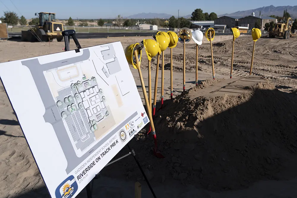 plan Construction site with plan prominently displayed next to row of hard hats